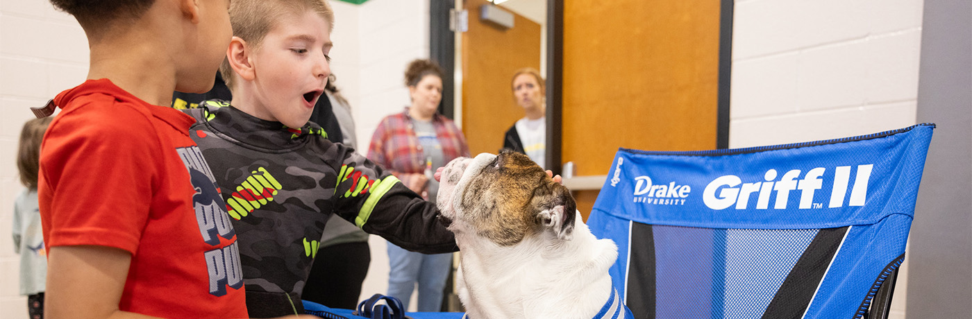 students petting Griff the mascot dog